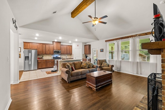 living area with high vaulted ceiling, beamed ceiling, wood finished floors, and visible vents