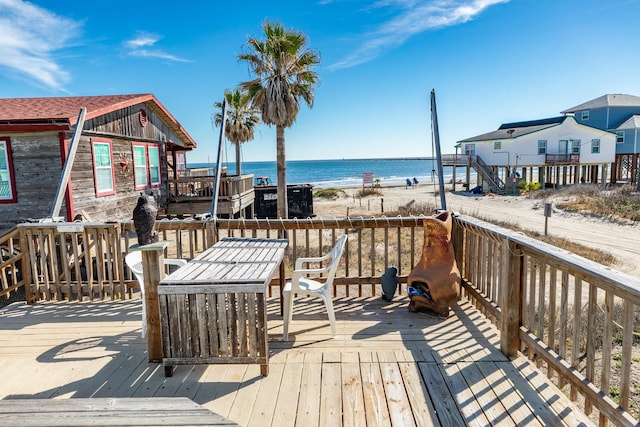 deck with a view of the beach and a water view