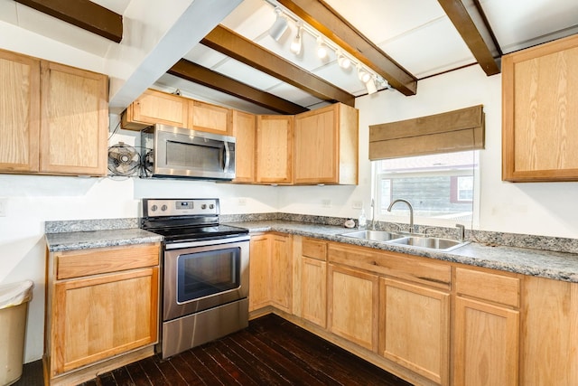 kitchen featuring beam ceiling, appliances with stainless steel finishes, a sink, and light brown cabinetry