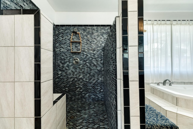 bathroom with a garden tub and a tile shower