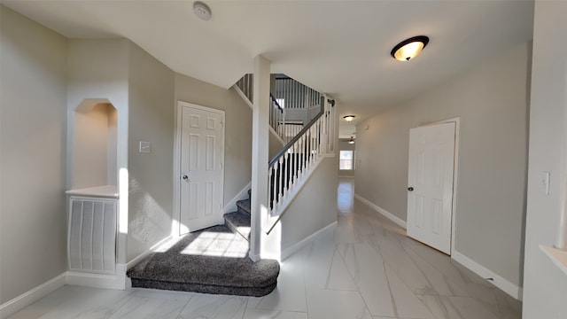 foyer entrance with marble finish floor, visible vents, stairway, and baseboards