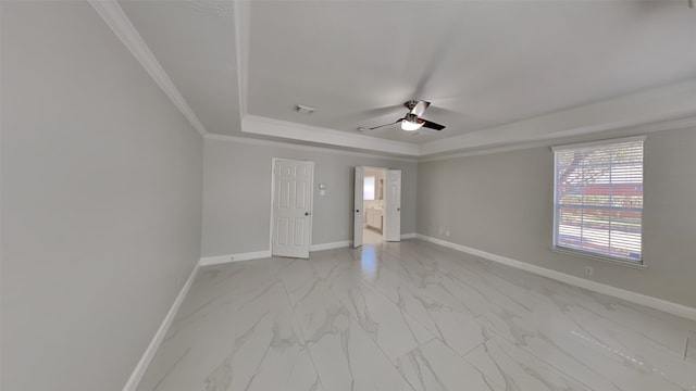 spare room with visible vents, baseboards, ornamental molding, marble finish floor, and a tray ceiling