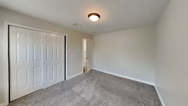 unfurnished bedroom featuring carpet, a closet, visible vents, and baseboards