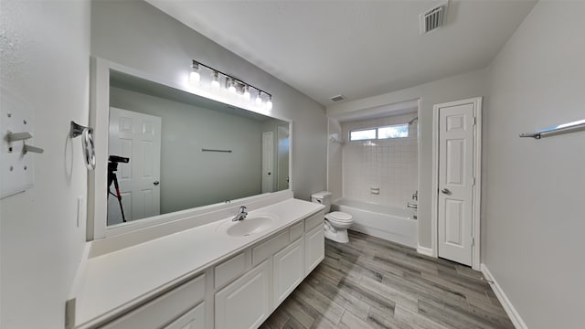 full bath featuring visible vents, toilet, shower / tub combination, wood finished floors, and vanity