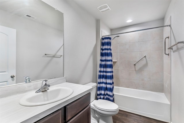 bathroom with toilet, wood finished floors, vanity, and visible vents