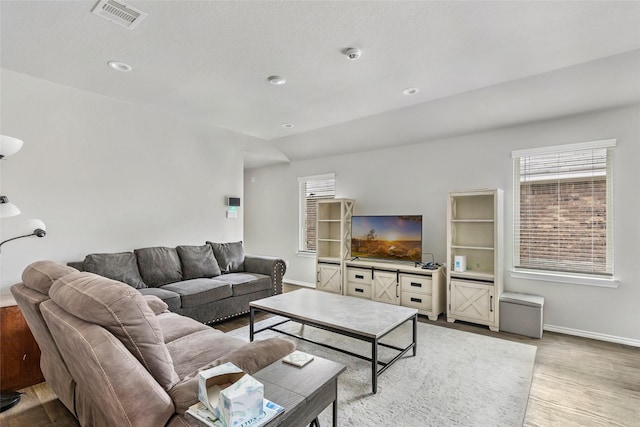 living area featuring recessed lighting, light wood-type flooring, visible vents, and baseboards