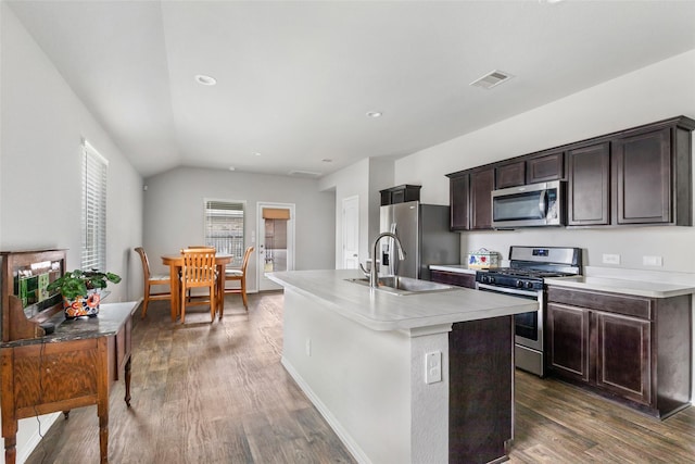 kitchen with wood finished floors, visible vents, light countertops, appliances with stainless steel finishes, and an island with sink