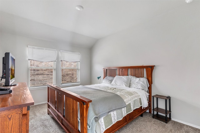 carpeted bedroom with lofted ceiling and baseboards