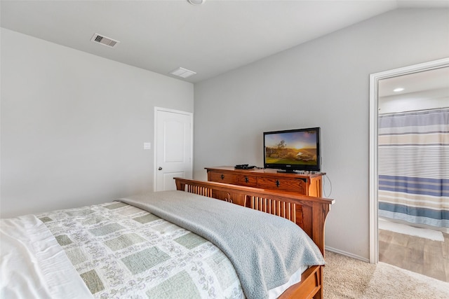 bedroom featuring lofted ceiling, carpet flooring, visible vents, and baseboards