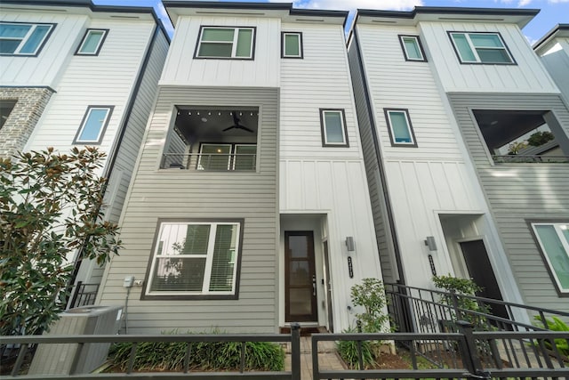 view of front of home with a fenced front yard, central AC, and board and batten siding