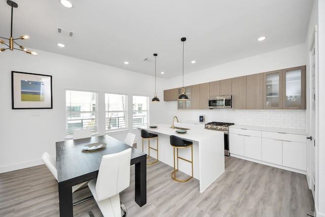 kitchen with stainless steel appliances, visible vents, decorative backsplash, and modern cabinets