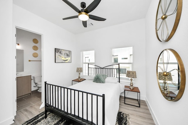 bedroom with baseboards, ensuite bath, visible vents, and light wood-style floors