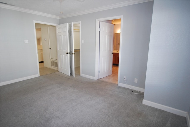 unfurnished bedroom with baseboards, carpet floors, a spacious closet, and crown molding