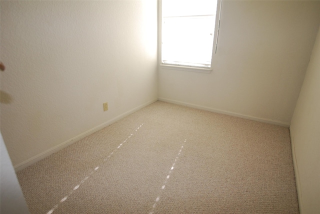 carpeted empty room with baseboards