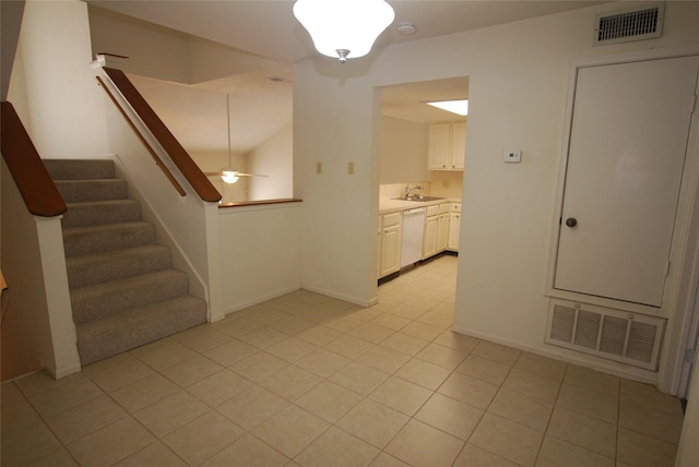 interior space with stairway, light tile patterned floors, visible vents, and a sink