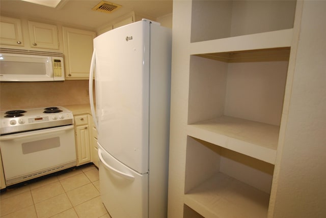 kitchen with light countertops, white appliances, visible vents, and light tile patterned floors