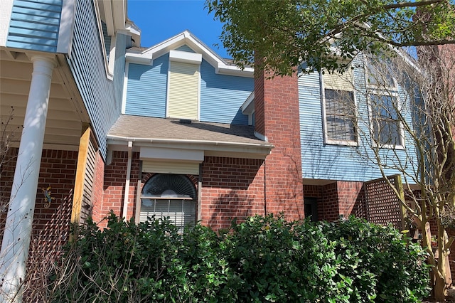 view of side of property featuring brick siding and a chimney