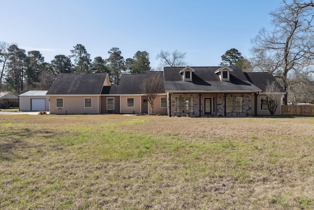 view of front of home with a front lawn, a detached garage, and fence