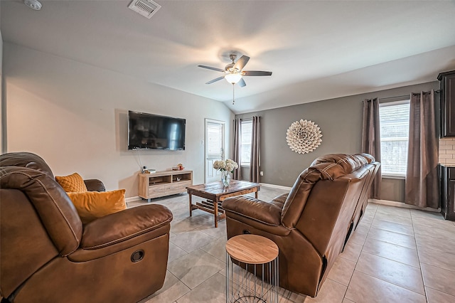 living area with light tile patterned floors, visible vents, vaulted ceiling, and a ceiling fan