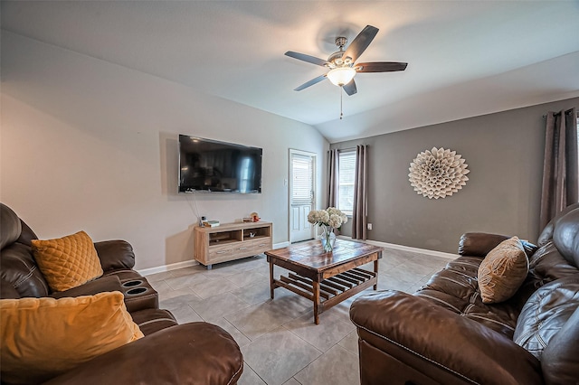 living room with lofted ceiling, light tile patterned flooring, ceiling fan, and baseboards