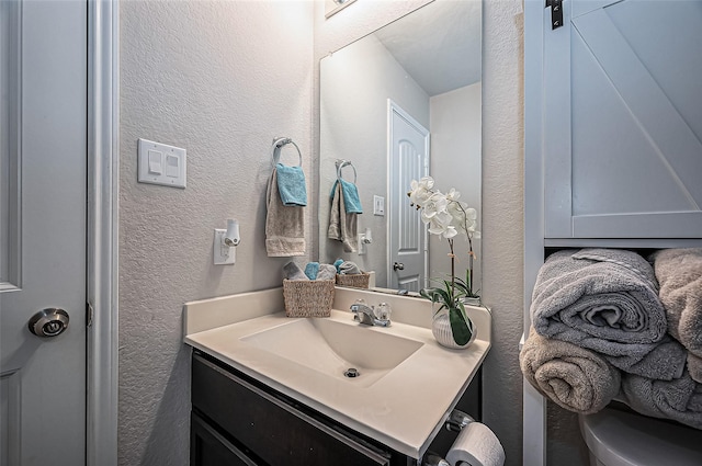 bathroom featuring a textured wall and vanity