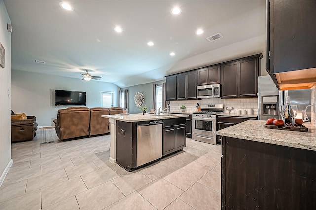 kitchen featuring visible vents, decorative backsplash, open floor plan, vaulted ceiling, and stainless steel appliances