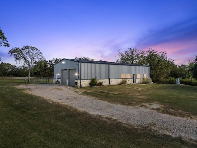 exterior space with a yard, a detached garage, fence, and an outbuilding