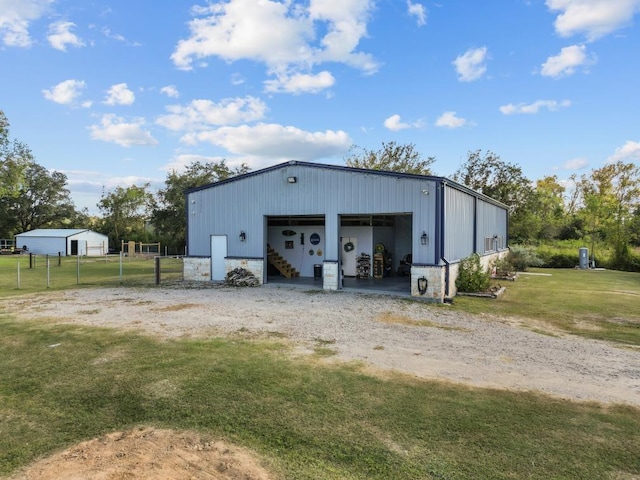 detached garage featuring fence and driveway