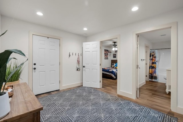 foyer with baseboards, wood finished floors, and recessed lighting