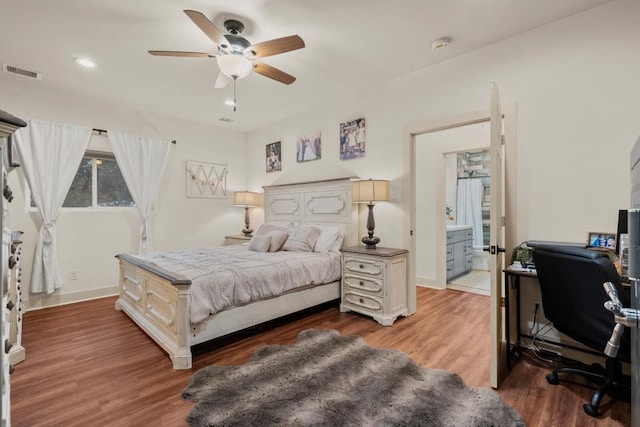 bedroom featuring baseboards, visible vents, ceiling fan, and wood finished floors