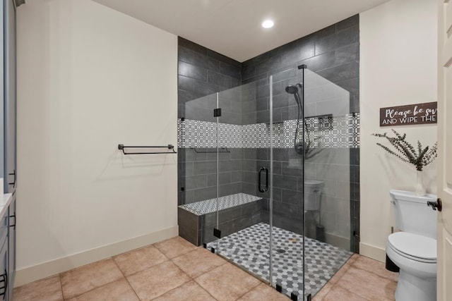 full bath featuring baseboards, a shower stall, toilet, and tile patterned floors