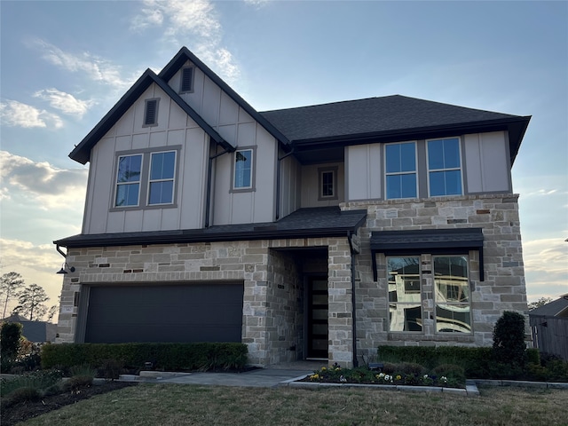 view of front of property with an attached garage, board and batten siding, and roof with shingles