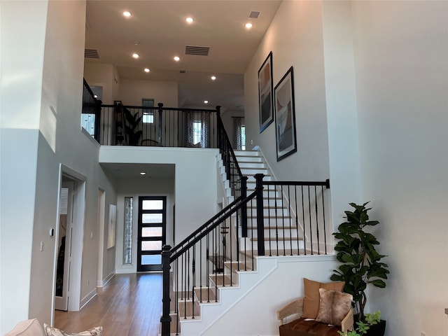 entryway with recessed lighting, visible vents, stairway, wood finished floors, and baseboards