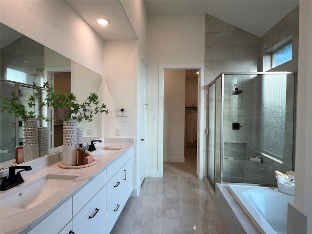 bathroom featuring lofted ceiling, double vanity, a stall shower, and a sink