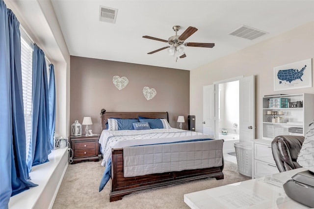 bedroom with light carpet, connected bathroom, visible vents, and a ceiling fan