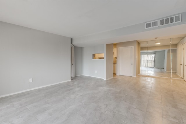 unfurnished room with baseboards and visible vents