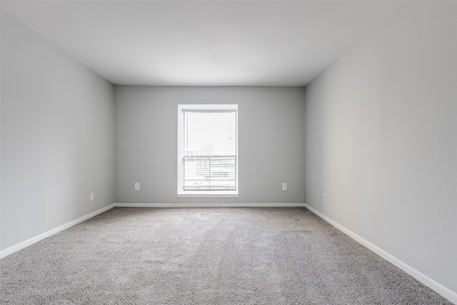 carpeted spare room with baseboards