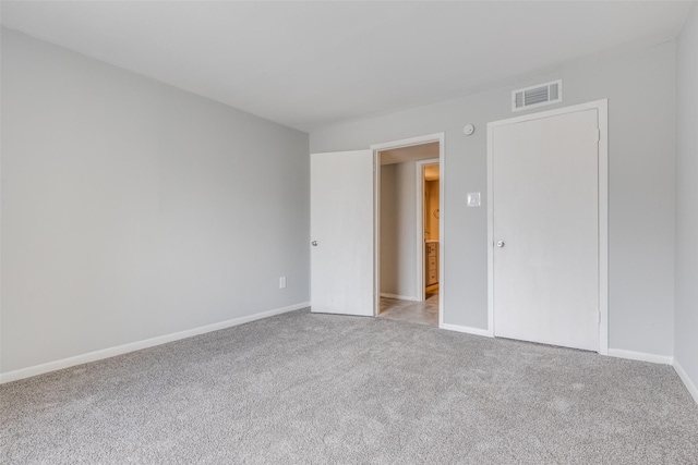 unfurnished bedroom featuring carpet, visible vents, and baseboards