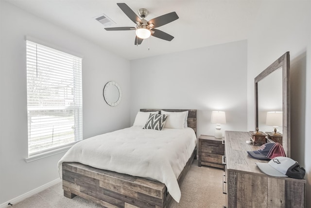 bedroom featuring light carpet, ceiling fan, visible vents, and baseboards