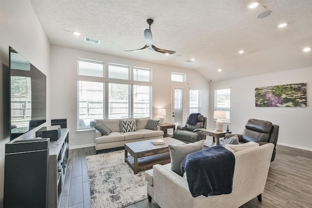 living room featuring a wealth of natural light, dark wood finished floors, and visible vents