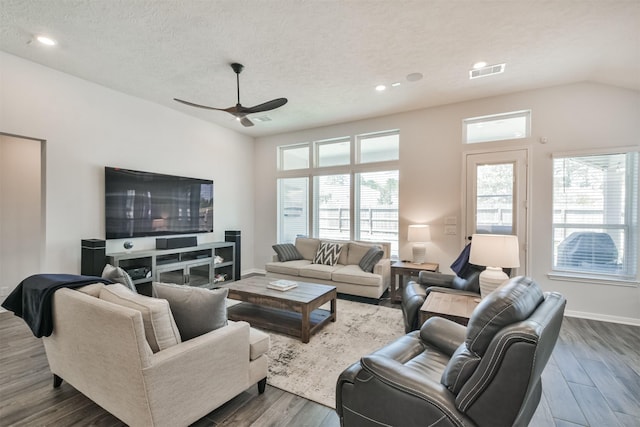 living area featuring baseboards, visible vents, ceiling fan, dark wood-type flooring, and a textured ceiling