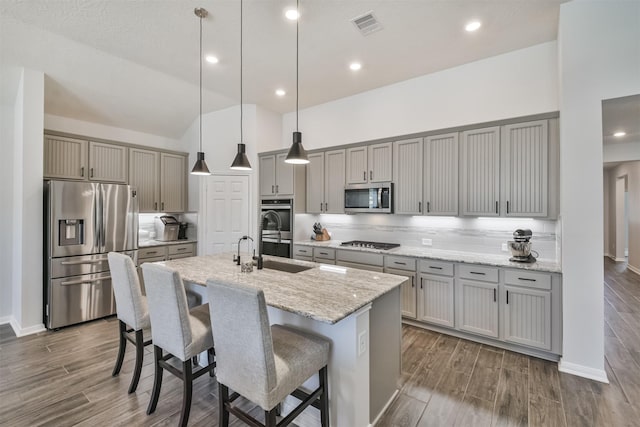 kitchen with a sink, visible vents, appliances with stainless steel finishes, gray cabinets, and wood tiled floor