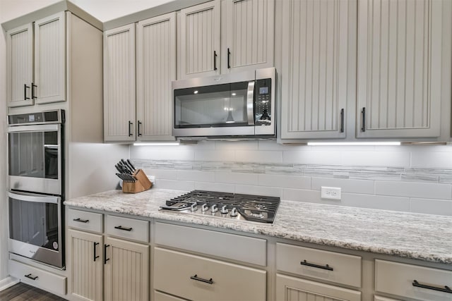 kitchen featuring light stone countertops, appliances with stainless steel finishes, and decorative backsplash