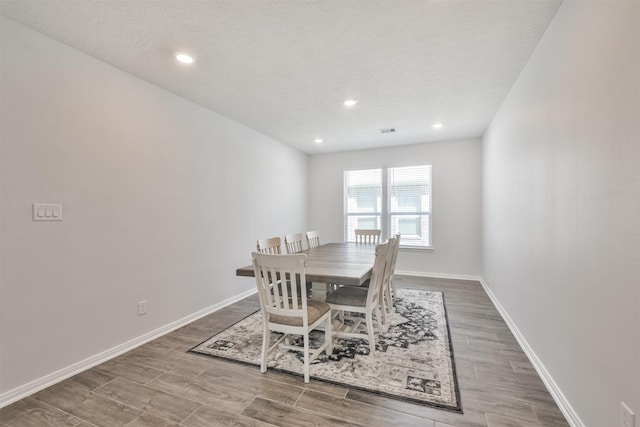 dining area featuring baseboards, wood finished floors, and recessed lighting