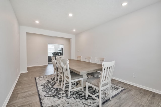 dining space with recessed lighting, baseboards, and light wood finished floors