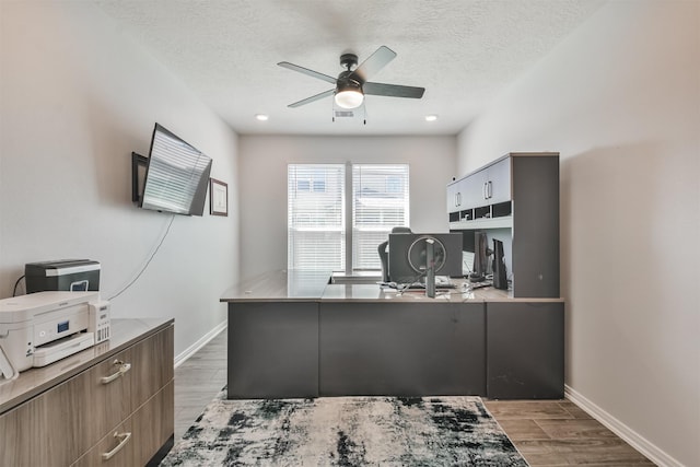 office with wood finish floors, ceiling fan, a textured ceiling, and baseboards