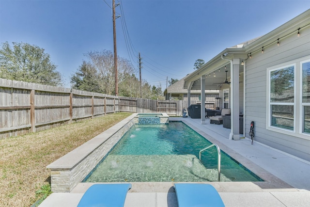 view of swimming pool with ceiling fan, a fenced backyard, area for grilling, a pool with connected hot tub, and a patio area