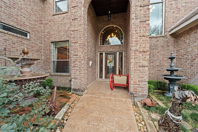 entrance to property featuring brick siding