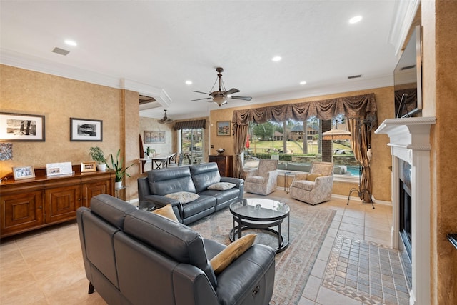 living room featuring ceiling fan, a fireplace, crown molding, and recessed lighting