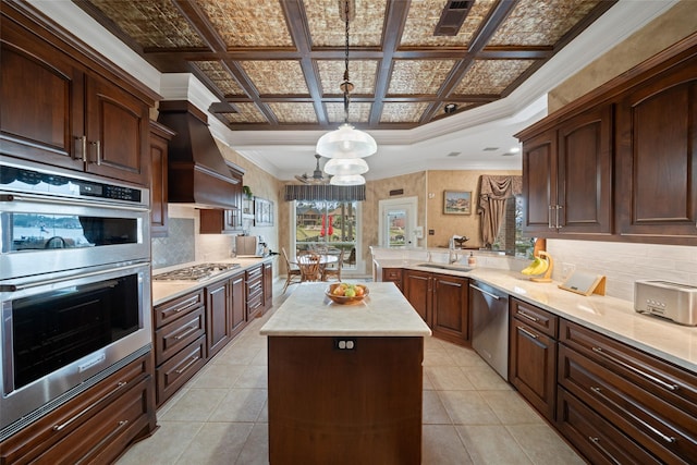 kitchen featuring coffered ceiling, appliances with stainless steel finishes, a center island, custom exhaust hood, and a sink